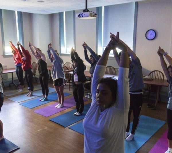 Students in a religion class practice yoga