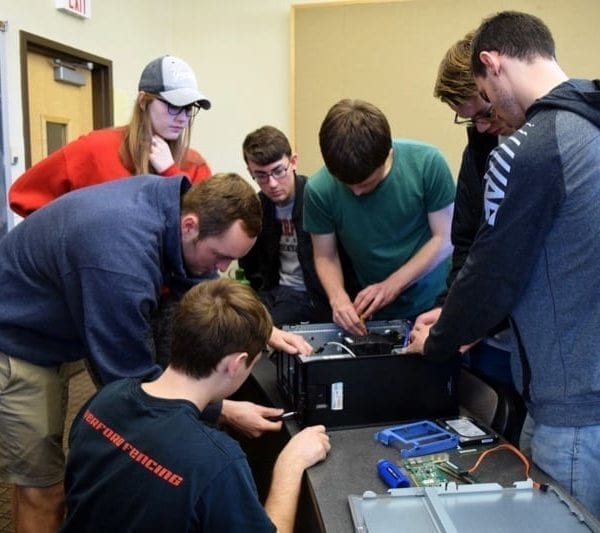 A group of students in Kristopher Micinski's class takes apart a computer in class.
