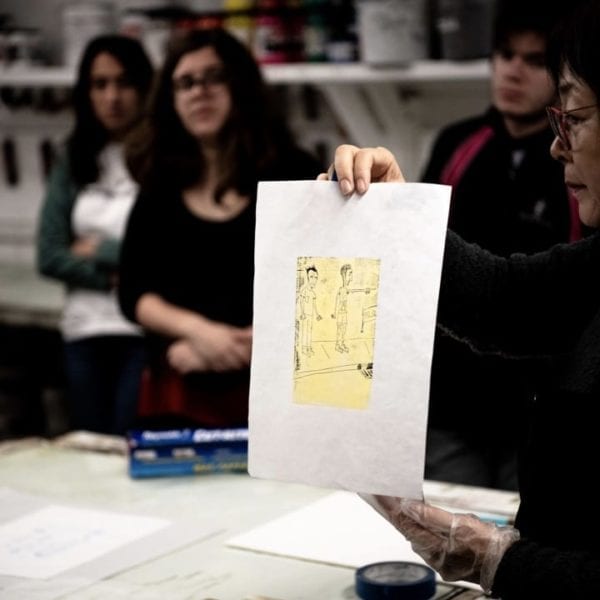 Hee Sook Kim holds up a print in class