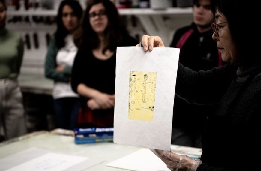 Hee Sook Kim holds up a print in class