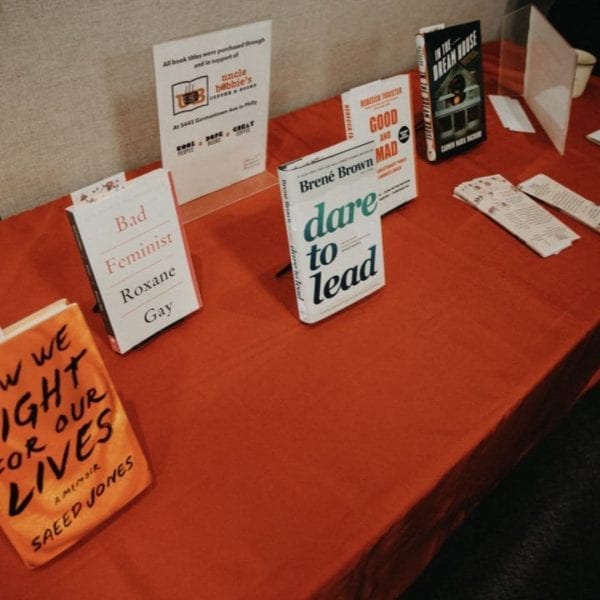 Copies of the suggested books on a long table with a red tablecloth