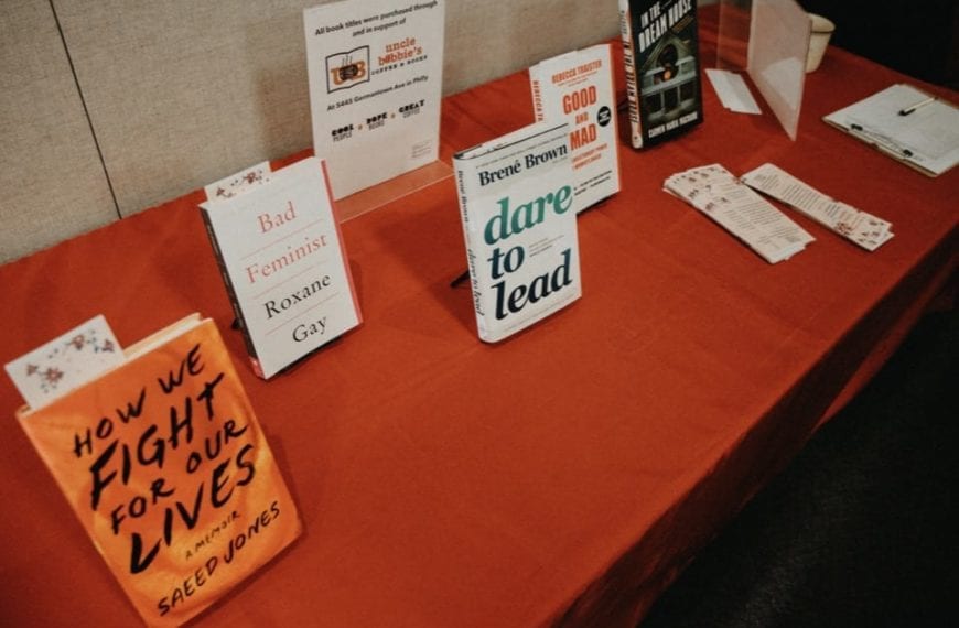Copies of the suggested books on a long table with a red tablecloth