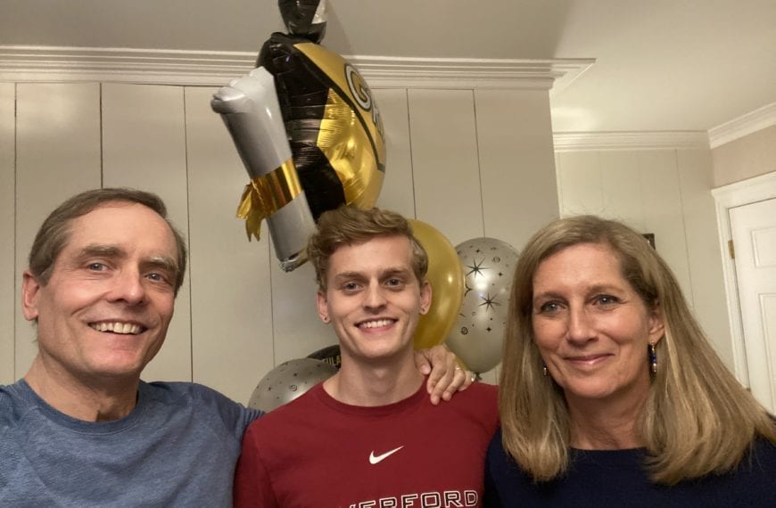 James Barker between his parents wearing a Haverford t-shirt and holding graduation balloons