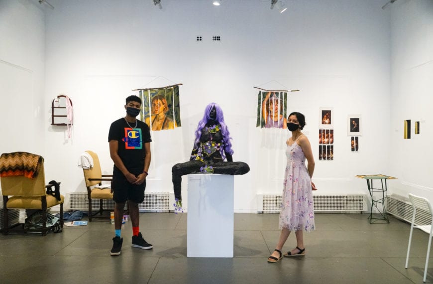 Jalen Martin '23 and Izzy Ray '23 stand in the student art center amidst the art pieces of In the Works, the exhibit they curated together.