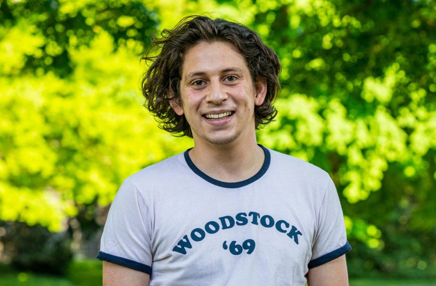 Headshot of Federico wearing white shirt with "Woodstock '69" in blue writing on it.