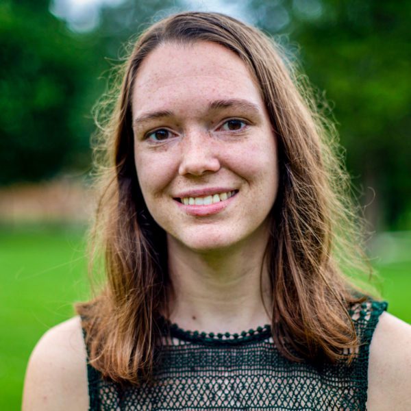 A headshot of Hannah in a field.