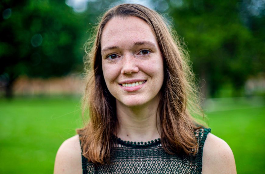 A headshot of Hannah in a field.