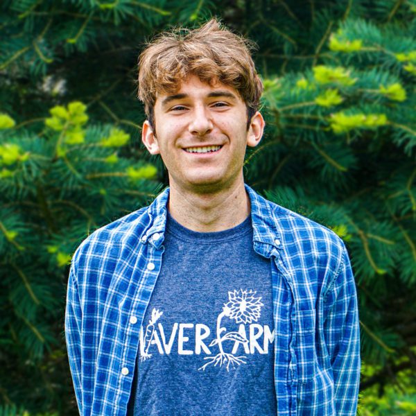 A photo of Jacob in front of a tree, wearing a blue Haverfarm shirt.