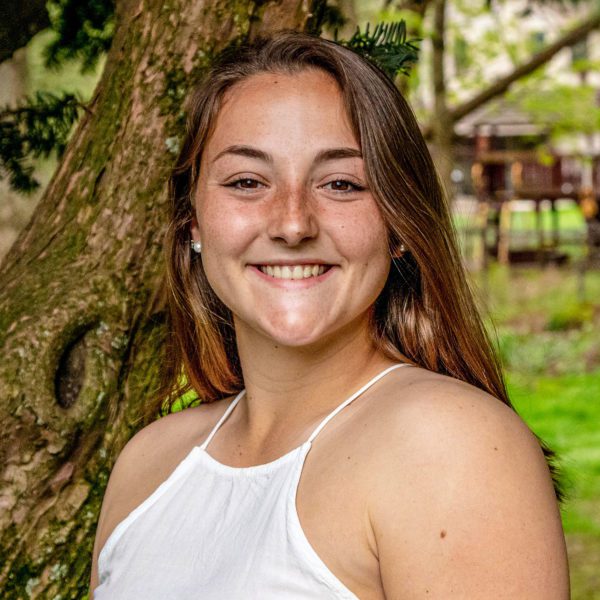 A picture of Johanna smiling at the camera in a white dress.