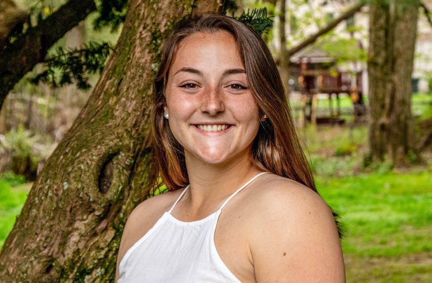 A picture of Johanna smiling at the camera in a white dress.