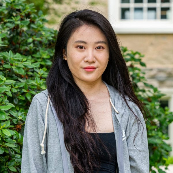 Headshot of Anqi standing to the side of Founders Hall.