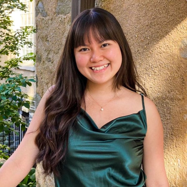 A picture of June in an emerald green top in front of Gest Hall.