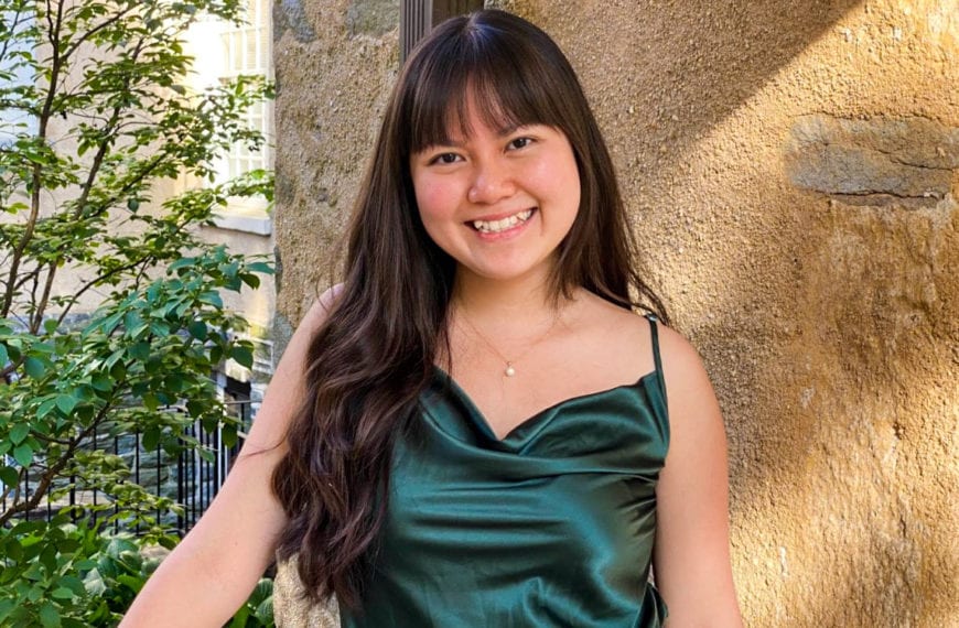 A picture of June in an emerald green top in front of Gest Hall.