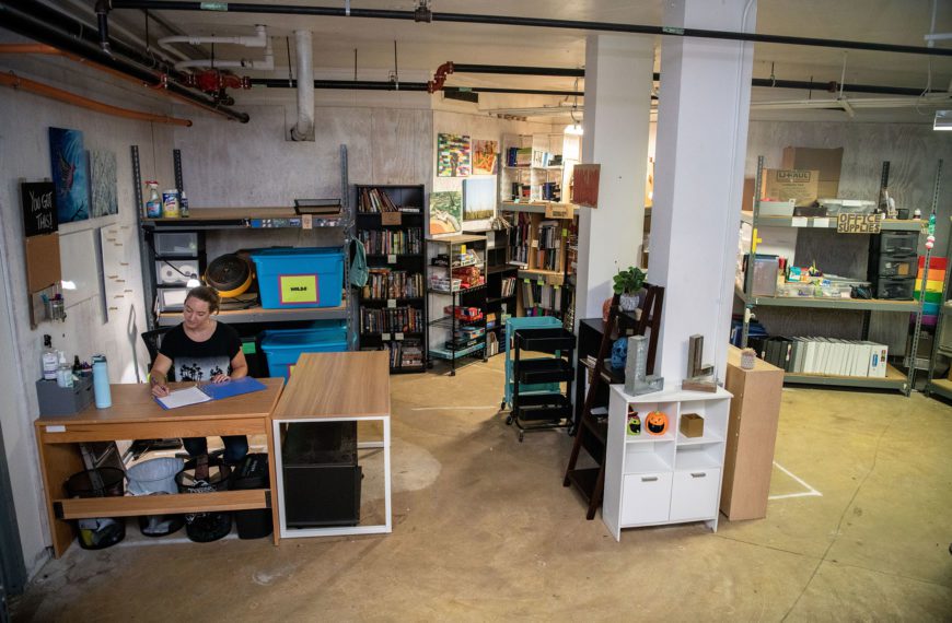 Arboretum Program Coordinator Jennie Ciborowski sits in the corner of the (RE)Use Store, surrounded by books and mini-fridges