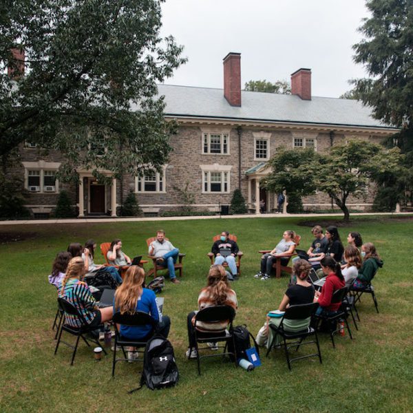 Students sit in a circle in folding chairs on Lloyd Green