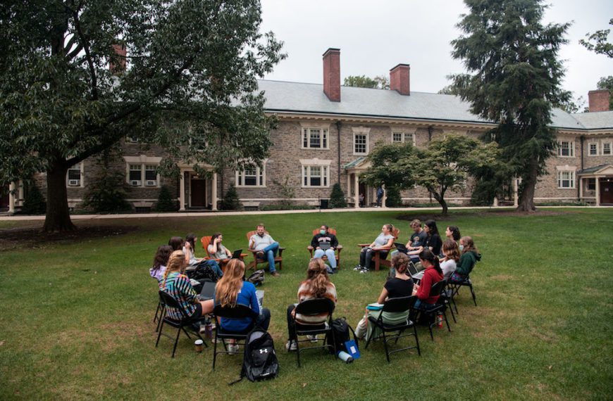 Students sit in a circle in folding chairs on Lloyd Green
