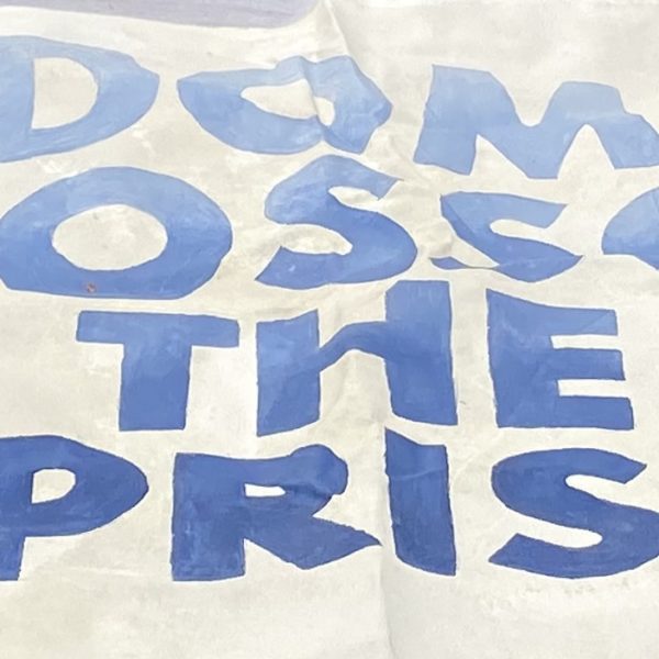 A protest sign that reads "Freedom Will Blossom From The Ashes Of Prisons"