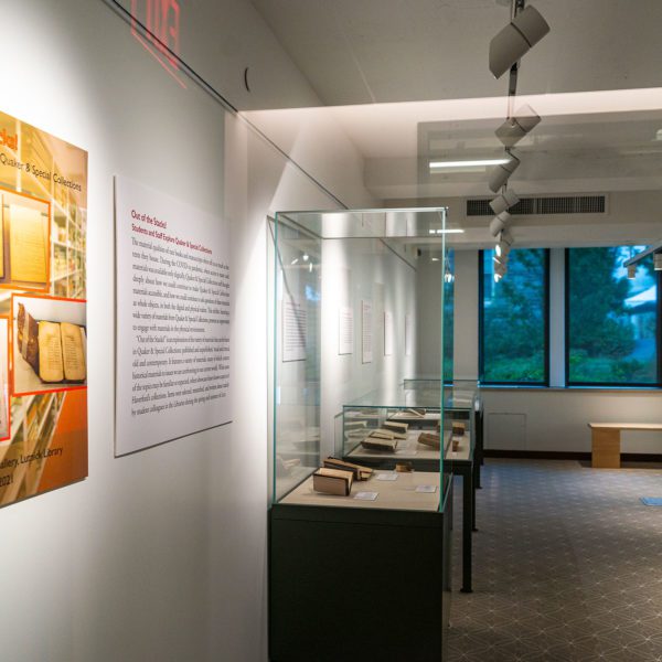 The wall signage for "Out of the Stacks" and several of the glass exhibition cases filled with items from Special Collections.