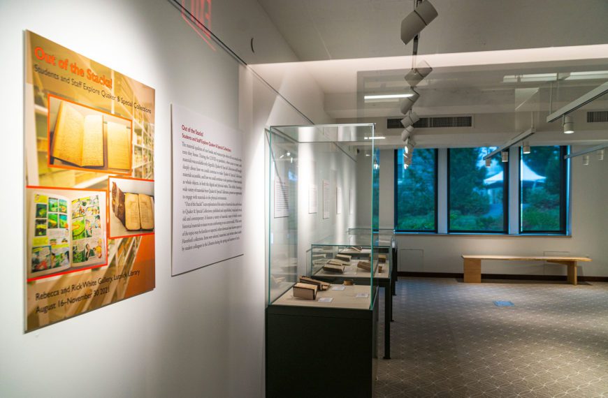 The wall signage for "Out of the Stacks" and several of the glass exhibition cases filled with items from Special Collections.
