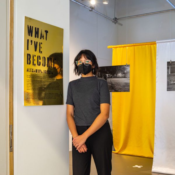 Lexie Iglesia '21 at the entrance of their exhibition, "What I've Become."