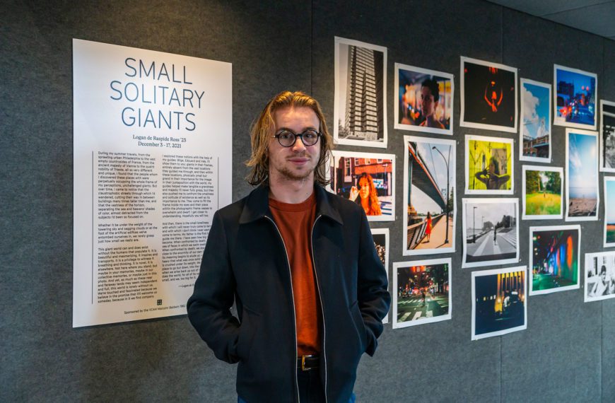 Logan de Raspide Ross '23 standing in front of the poster board at his new exhibition.