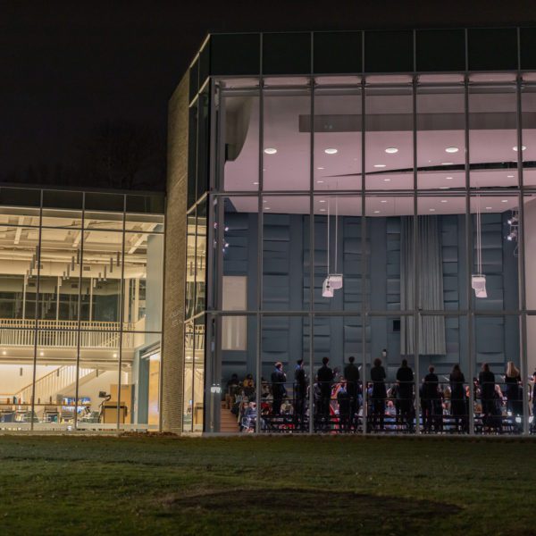 Jaharis Recital Hall lit up at night with the Chamber Singers Concert viewable from outside.