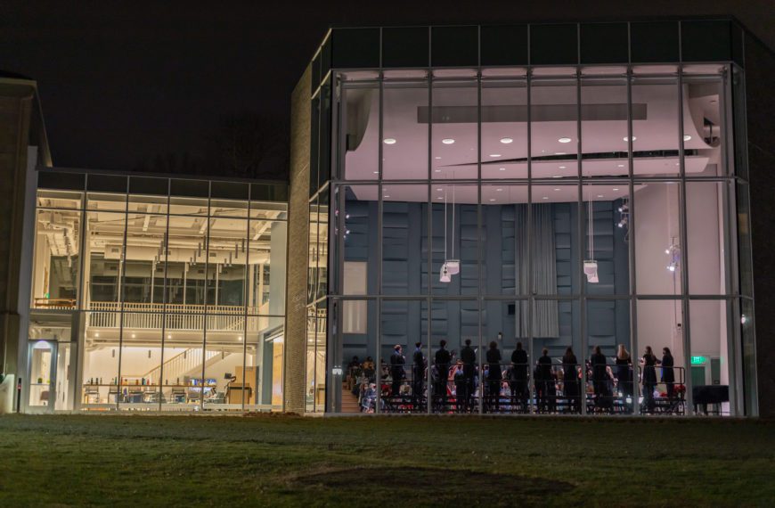 Jaharis Recital Hall lit up at night with the Chamber Singers Concert viewable from outside.