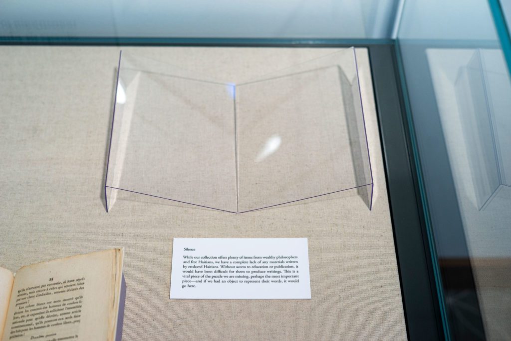 An empty clear, plastic book display with a label explaining what is missing.