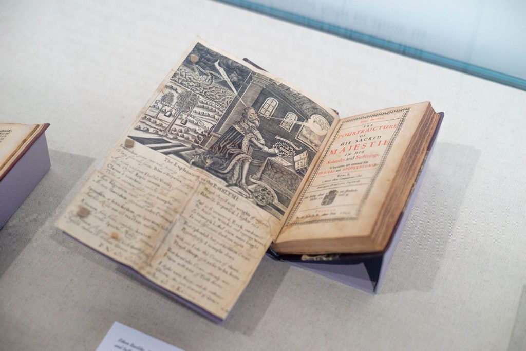 An old book with a fold-out drawing of a king with his eye on a crown in the sky and his hands on a crown of thorns.