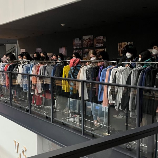 Several students browse racks of clothes in VCAM's lobby