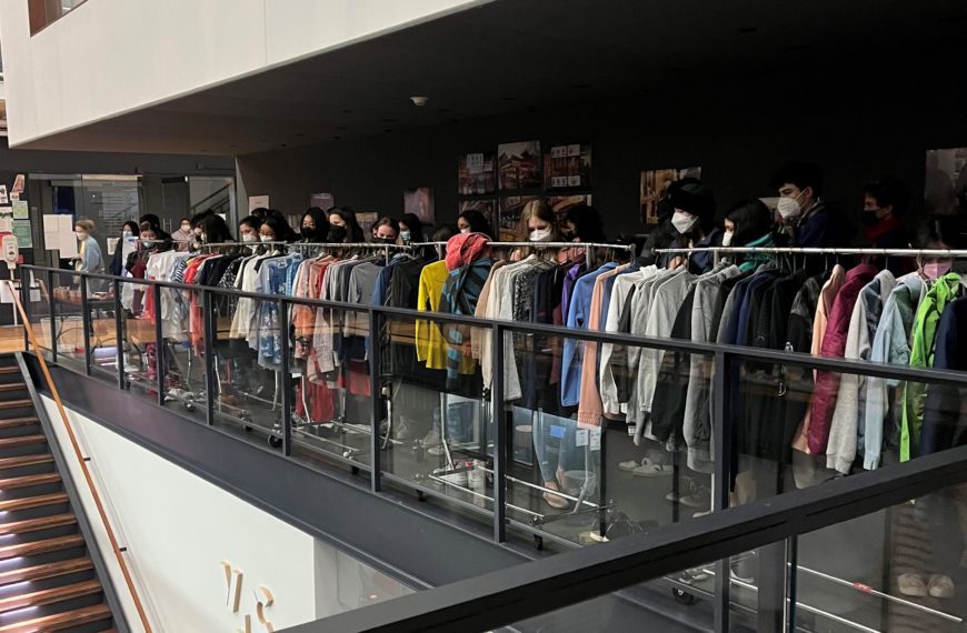Several students browse racks of clothes in VCAM's lobby