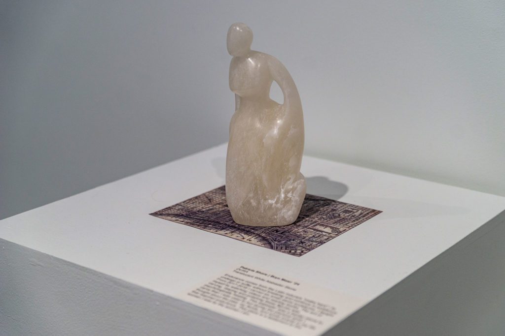 A small quartz statue of a woman.