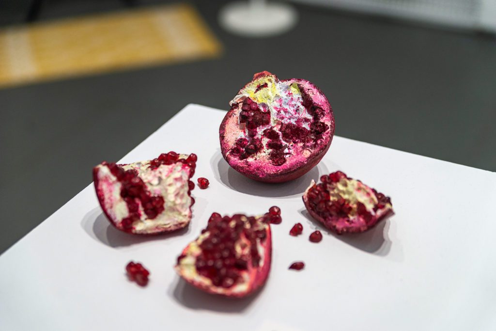 A pomegranate broekn into four pieces