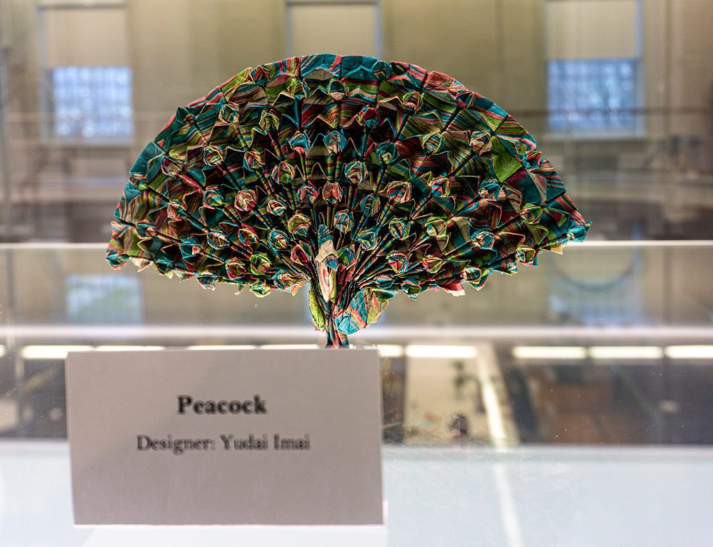 A multicolored peacock made of elaborate folds.
