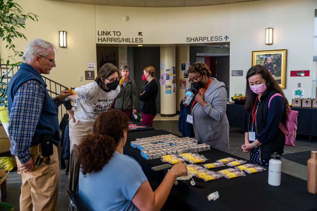 People talk and enjoy ice cream in KINSC Rotunda after the conference's conclusion.