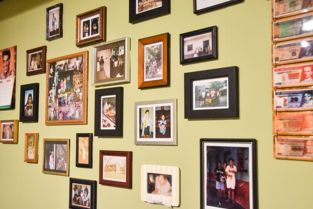 A wall of family photos and a calendar and Guatemalan money.