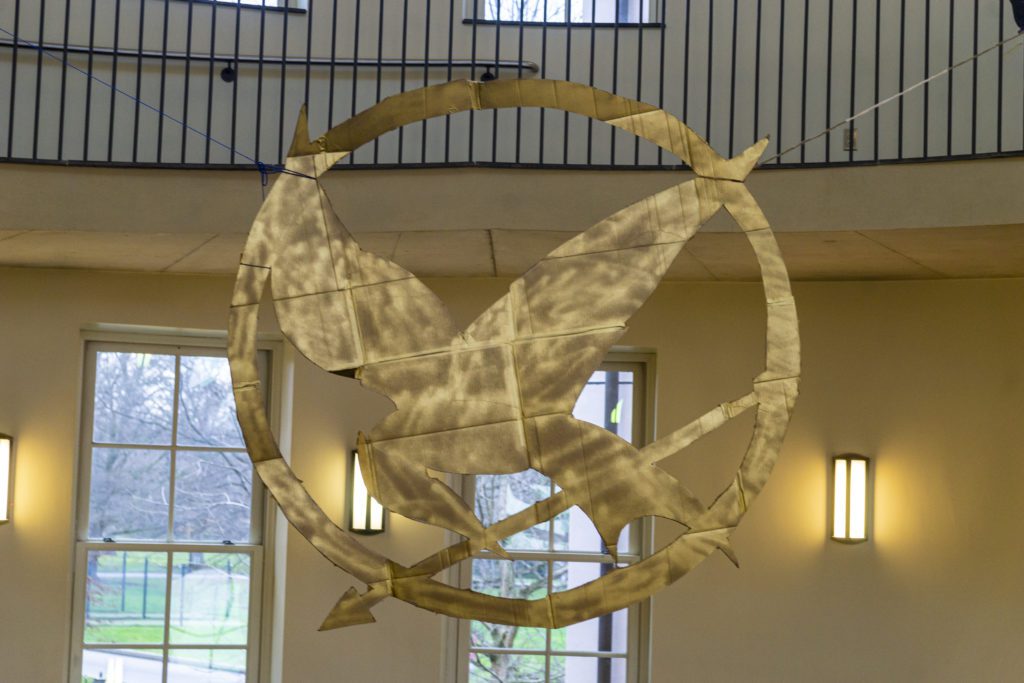 A giant, gold, 3-d mockingjay hangs in the KINSC rotunda