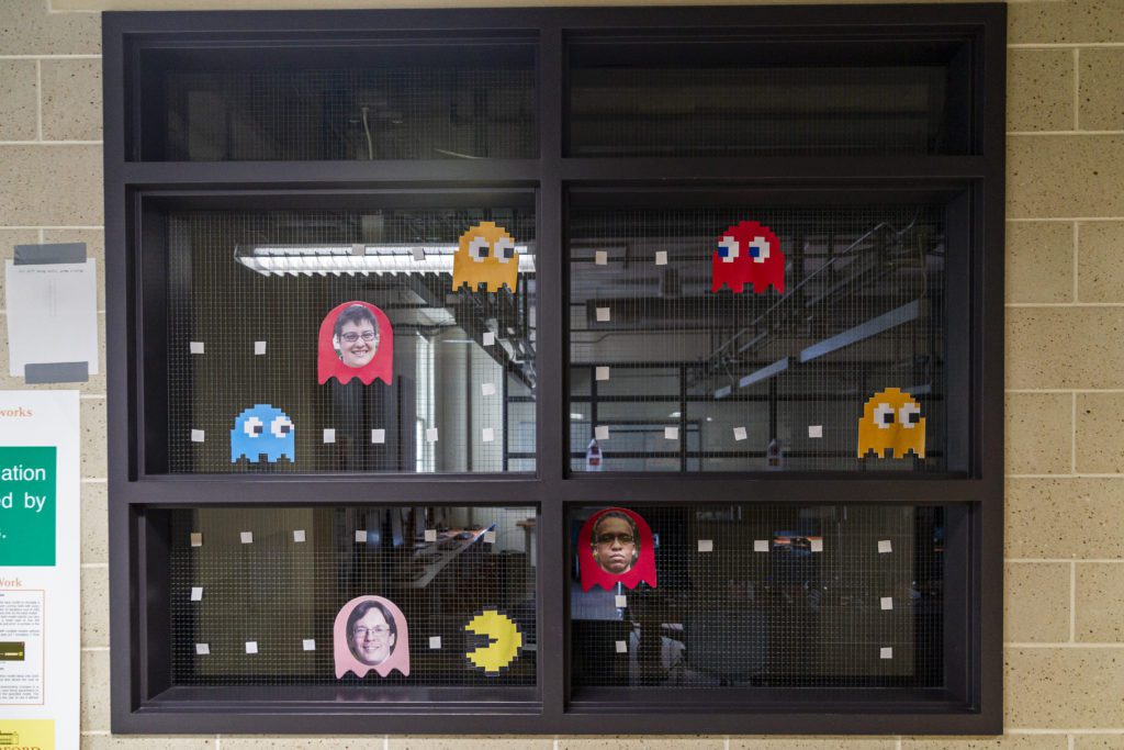 Computer science professors' faces glued onto Pac Man characters on the wall