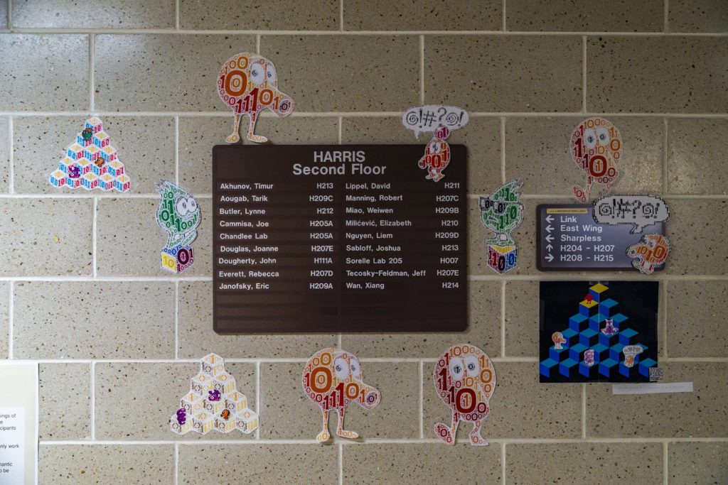 Many cutout Qberts are posed on the wall of Harris