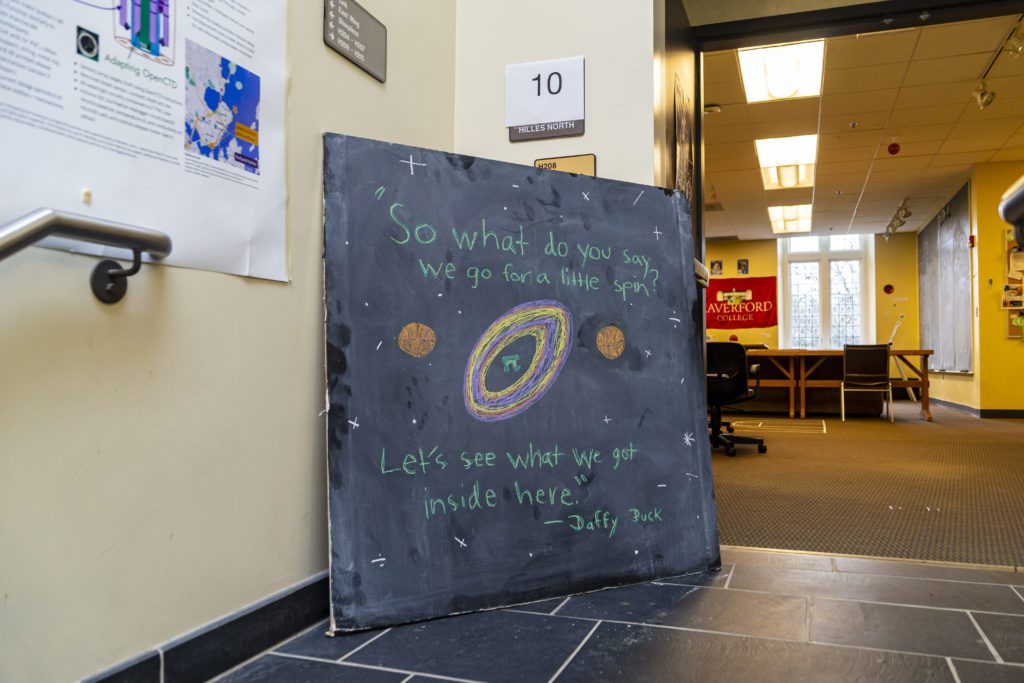 A chalkboard in front of the Math Lounge with a quote from Daffy Duck: "So what do you say we go for a little spin? Let's see what we got inside here."