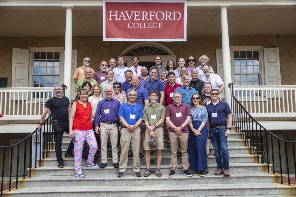 About 30 members of the Class of 1987 pose under a red Haverford College banner.