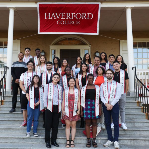 Chesick Scholars stand on the porch of Founders Hall under a poster saying Haverford College