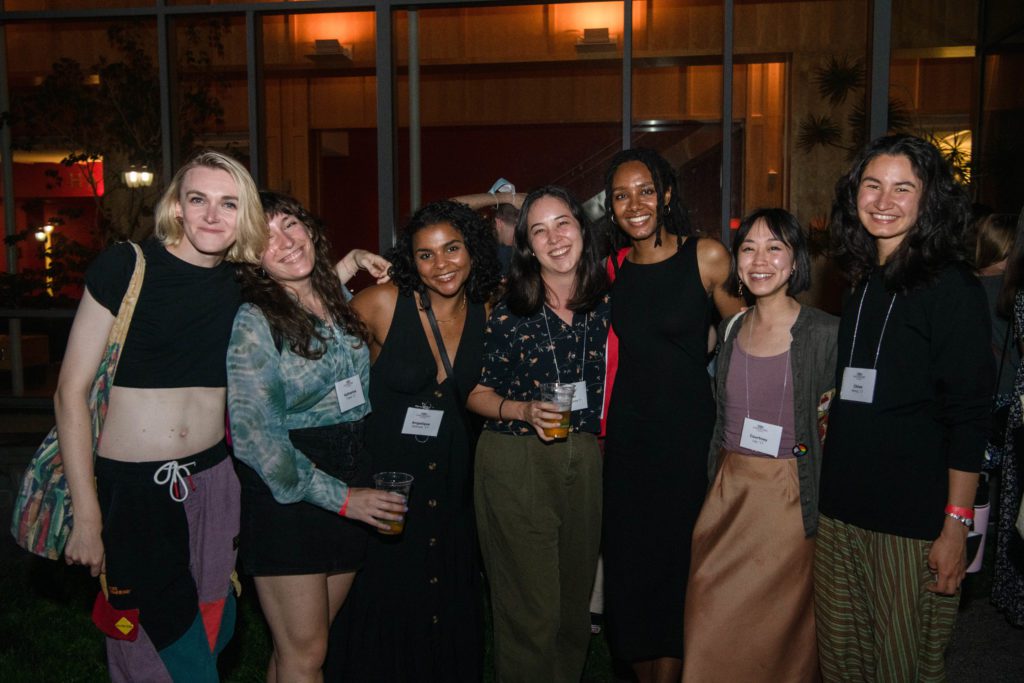 Seven members of the Class of 2017 pose with their arms around each other, smiling, in front of the GIAC.