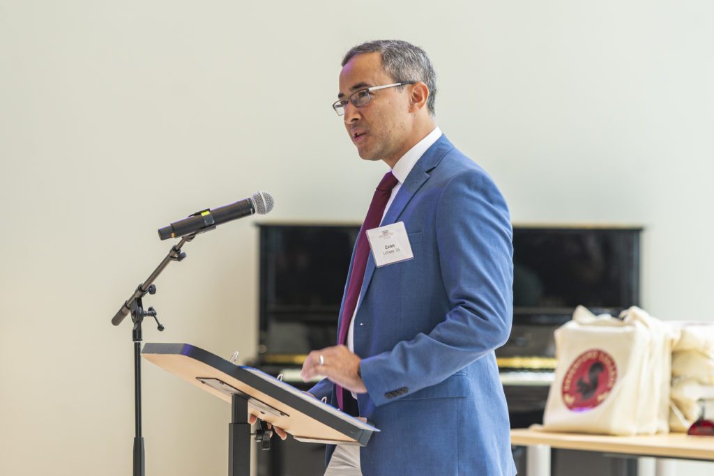 Evan LeFlore '06 looks serious in a jacket and tie as he speaks at the microphone
