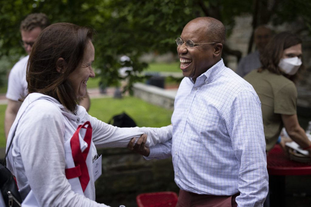 Garry smiles widely grabbing his classmate's arm.