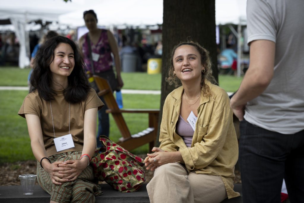 Two members of the Class of 2017 sit on a bench and smile