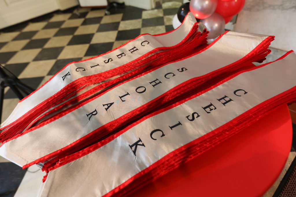 Chesick Scholar sashes with red trim on a table ready to be given out.