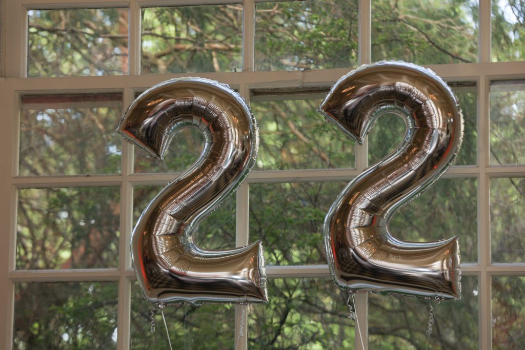 Mylar balloons saying "22" against the windows in the Great Hall.