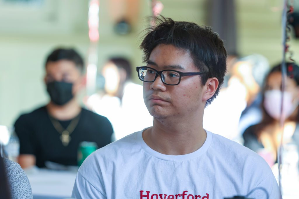 Junior Nguyen looks towards the speaker at the podium at the banquet
