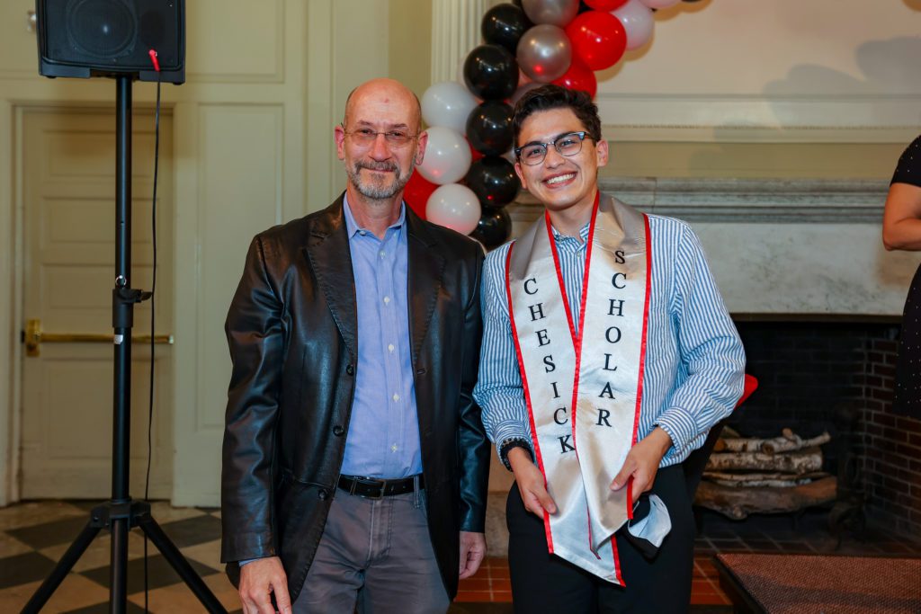 Jeff and Brandon give big smiles with a balloon arch in the background